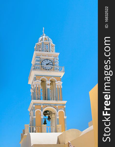 High church tower with clocks and also balcony and cross of top of this. Island of Santorini, Fira, Greece. High church tower with clocks and also balcony and cross of top of this. Island of Santorini, Fira, Greece.