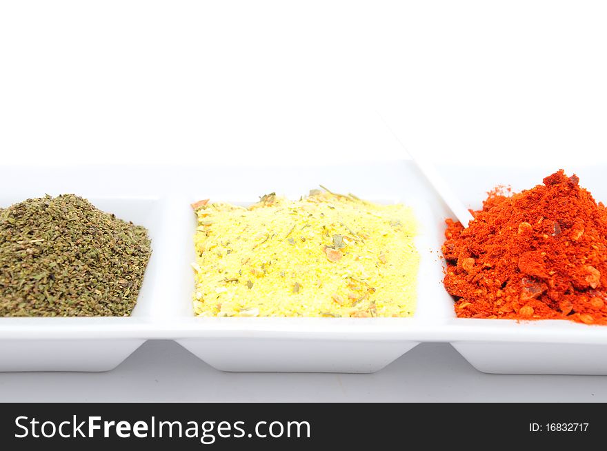 Spices in a white bowl on wooden table