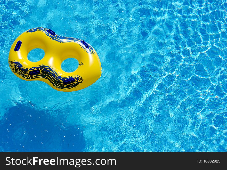 Yellow rubber ring floating in blue water