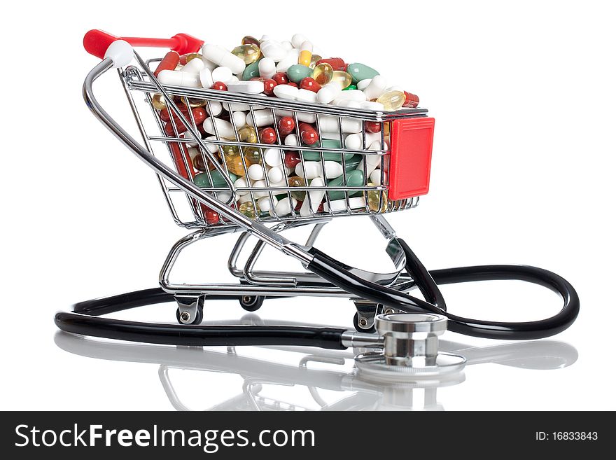 Shopping cart full with pills/capsules and a stethoscope on a white background. Shopping cart full with pills/capsules and a stethoscope on a white background