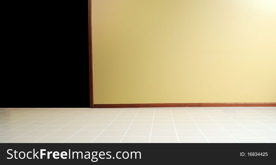 Empty room with a linoleum floor with a yellow painted wall