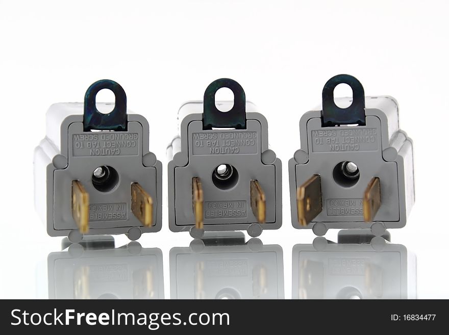 Gray electrical outlet plugin converters with reflection on isolated white background. Gray electrical outlet plugin converters with reflection on isolated white background