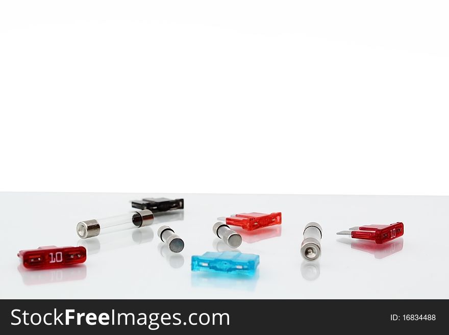 Car Fuses On Reflective Table On White Background