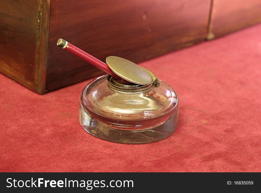 A glass pencil holder on a table