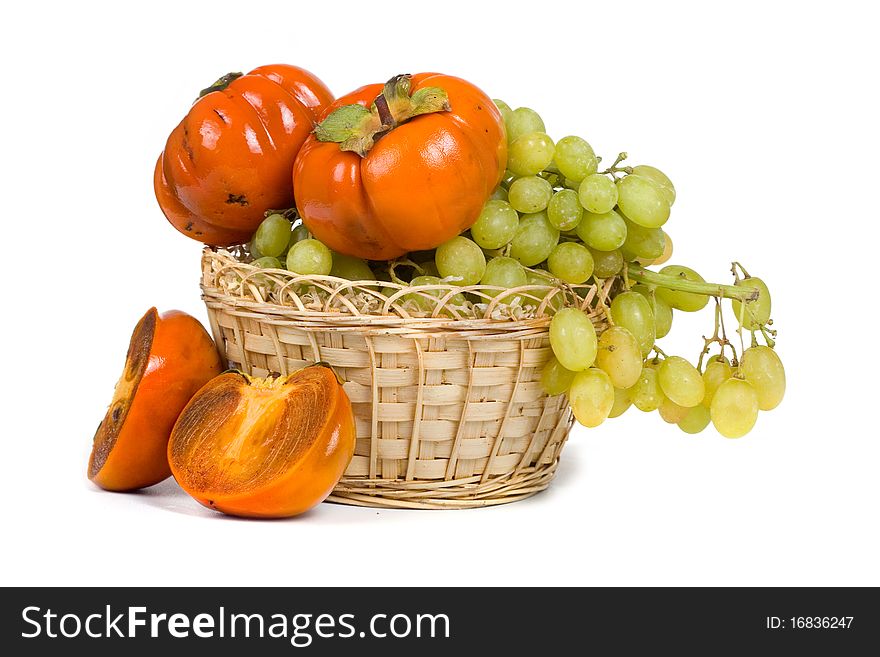 Ripe persimmons and grapes isolated on a white background