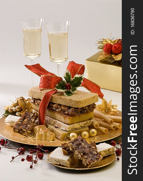Typical Spanish Christmas nougat in a golden plate. White background.