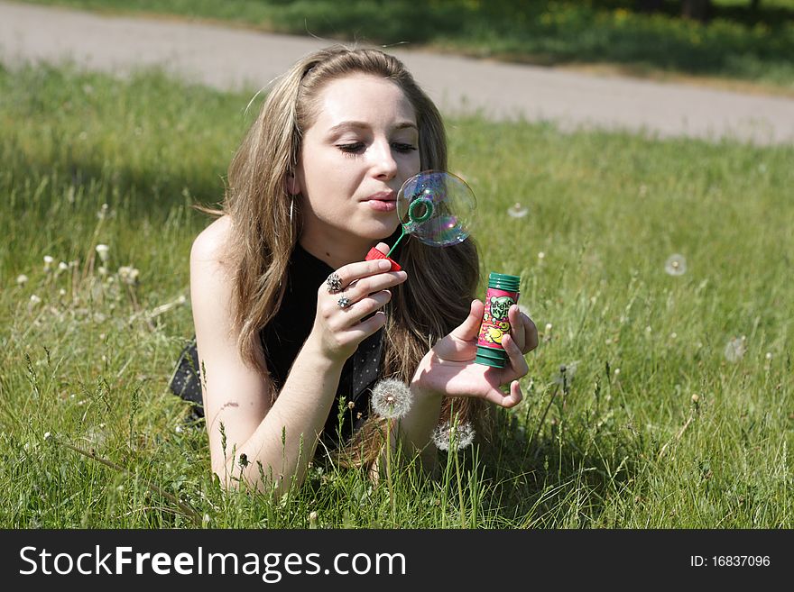 Young women lying on green grass in dandelions. Young women lying on green grass in dandelions