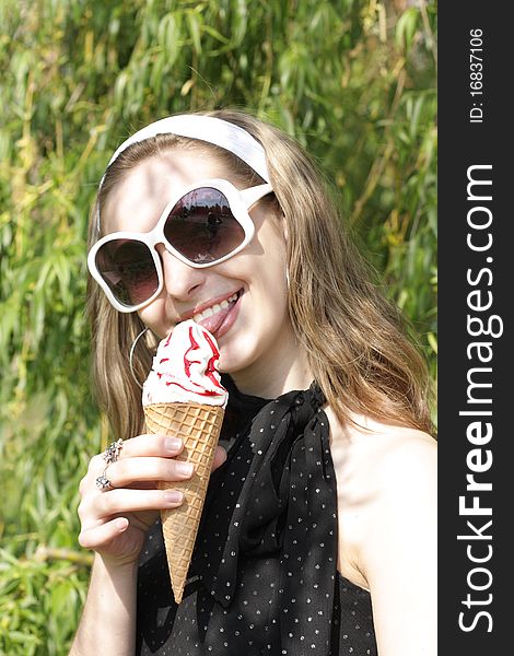 A young pretty teenage girl with ice cream cone outside