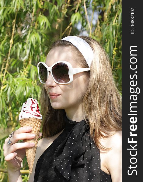 A young pretty teenage girl with ice cream cone outside