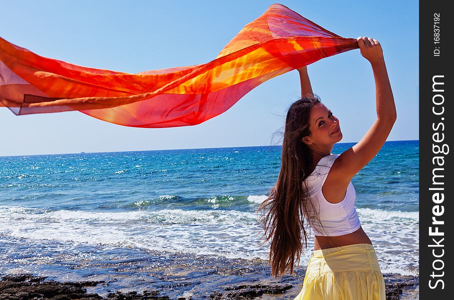 A young woman with the pareo is on a coast