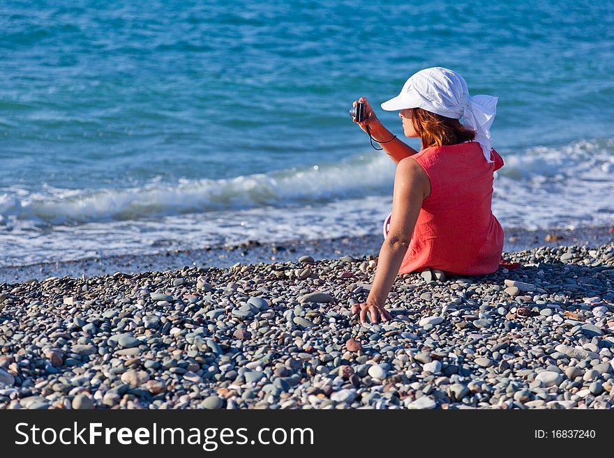 A woman with a camera on the coast