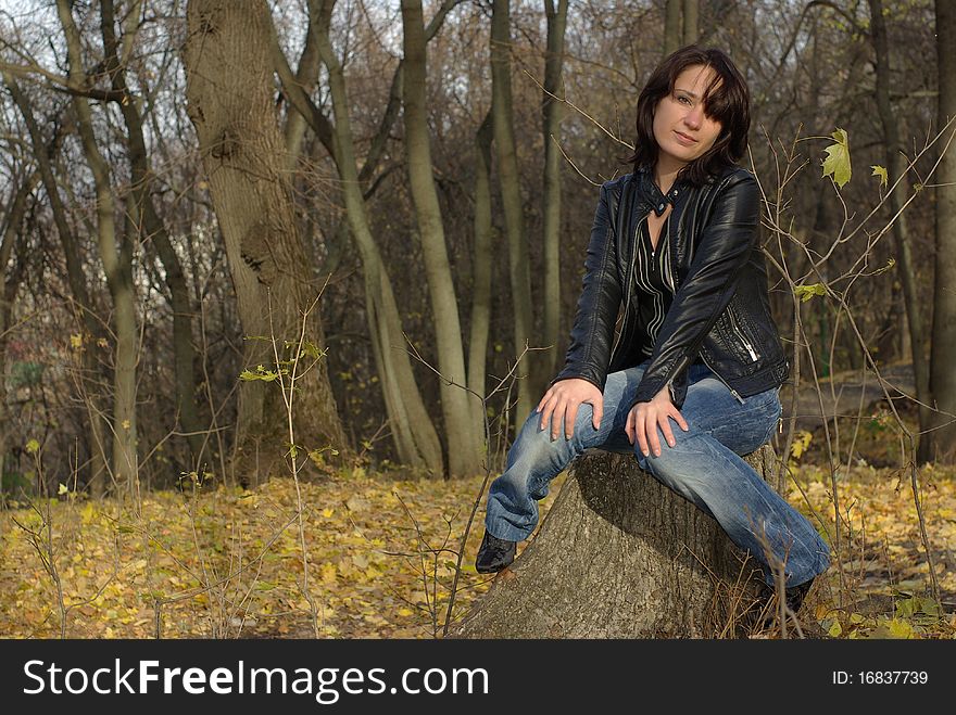 Thoughtful girl sitting on a tree stump. Thoughtful girl sitting on a tree stump