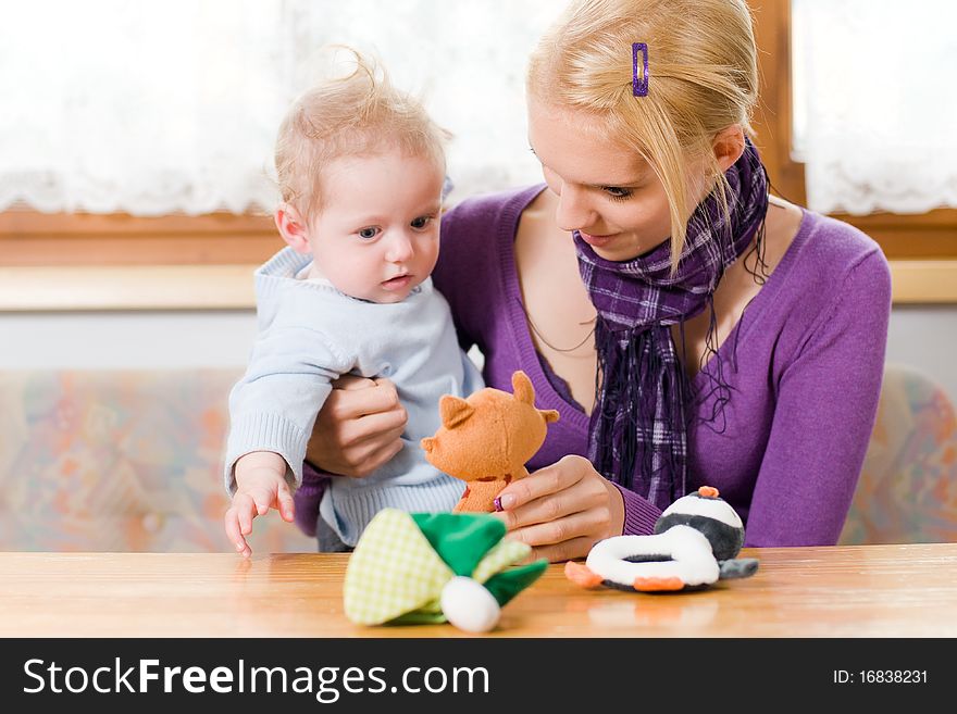 Young mother plays with her baby with toys. Young mother plays with her baby with toys
