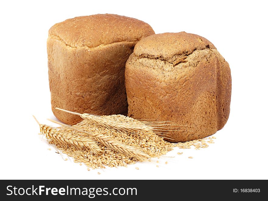 Homemade whole bread and stalks of wheat on a white background. Homemade whole bread and stalks of wheat on a white background