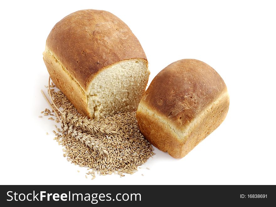 Homemade bread and stalks of wheat on a white background