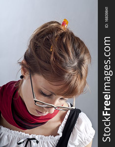 Blonde girl with glasses, pen and book that makes a teacher