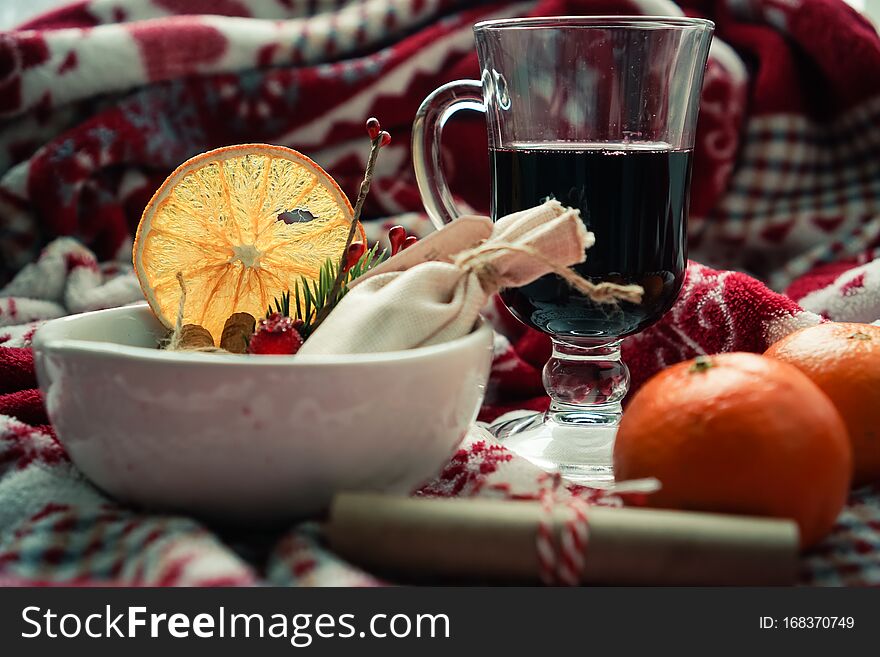 Christmas card with mulled wine and spices on a decorated blanket.