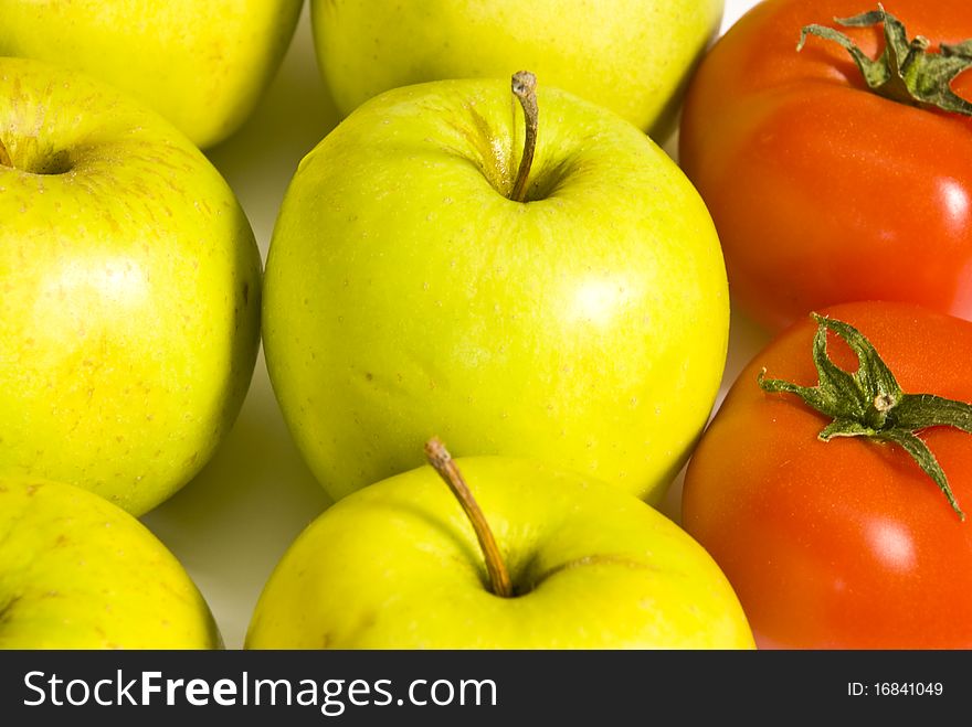 Red ripe tomatoes and green apples lie together, close-up. Red ripe tomatoes and green apples lie together, close-up