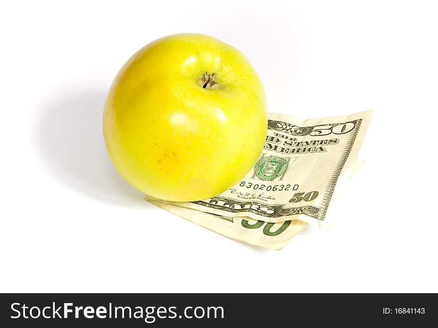 Green apple lying on the dollar banknote, on a white background. Green apple lying on the dollar banknote, on a white background