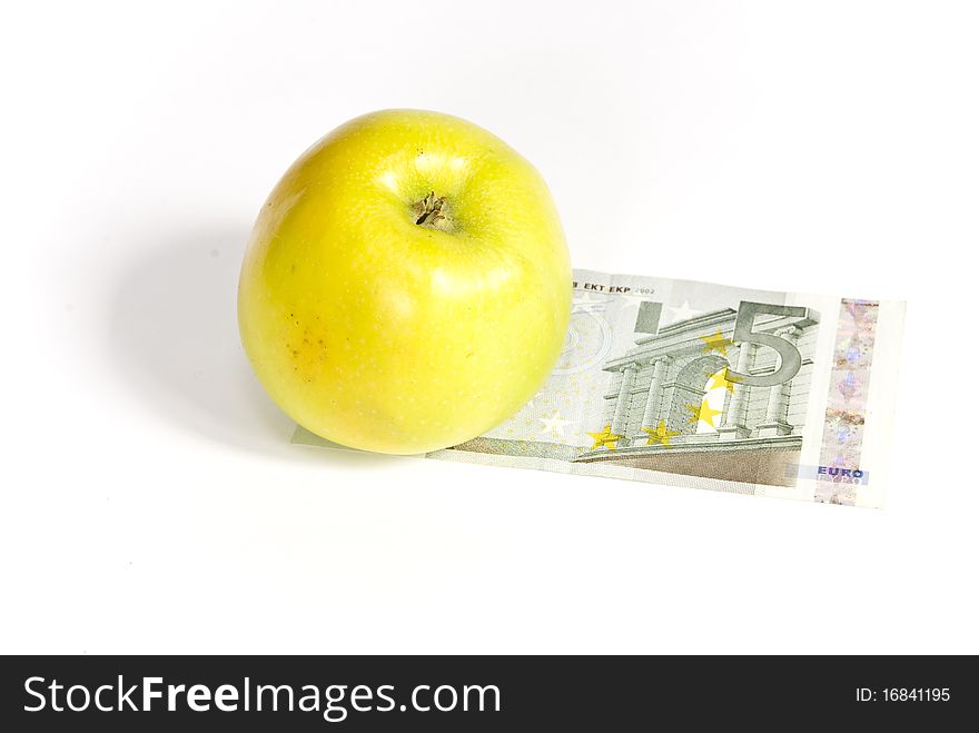 Green apple lying on the banknote, on a white background. Green apple lying on the banknote, on a white background