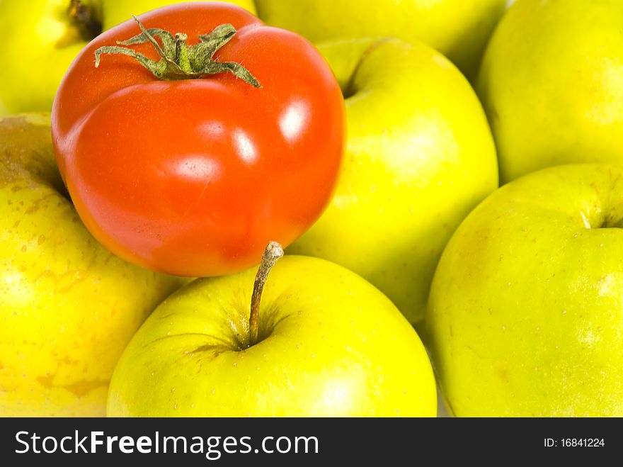 Red ripe tomato and some green apples closeup. Red ripe tomato and some green apples closeup