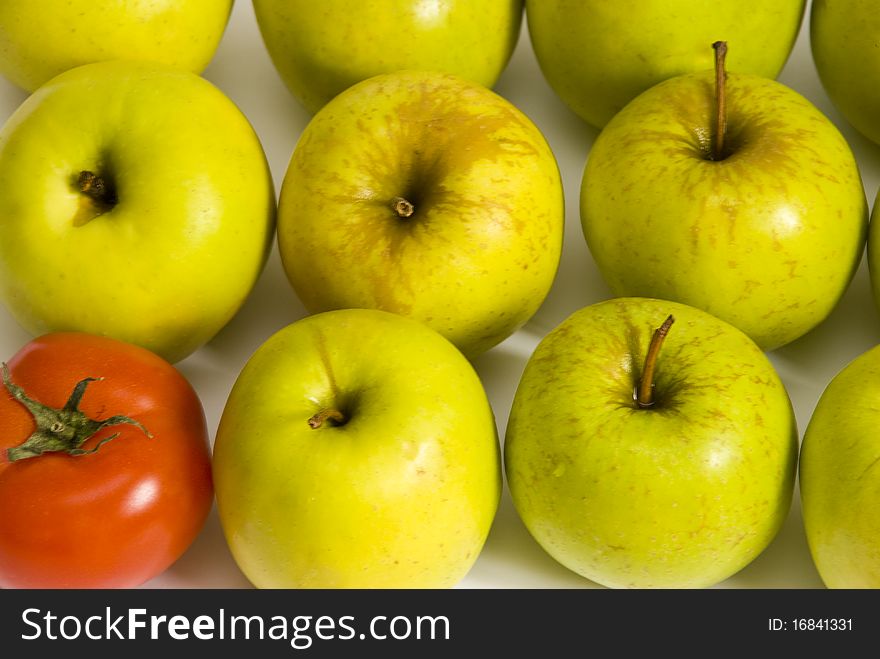 Red ripe tomato and some green apples closeup. Red ripe tomato and some green apples closeup