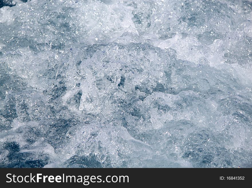 White sea spray in the blue water