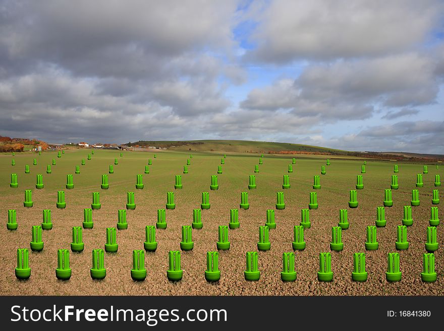 A concept image showing a field filled with low energy lightbulbs which are glowing fluorescent green in colour. A concept image showing a field filled with low energy lightbulbs which are glowing fluorescent green in colour.