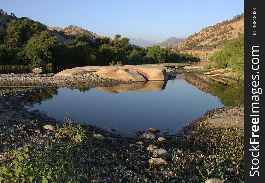 Little pond in Sierra Nevada with reflections of sky and rocks located near the town Three Rivers, California, US. Little pond in Sierra Nevada with reflections of sky and rocks located near the town Three Rivers, California, US