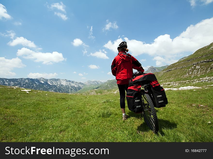 Woman with mountain bike on green valley. Woman with mountain bike on green valley