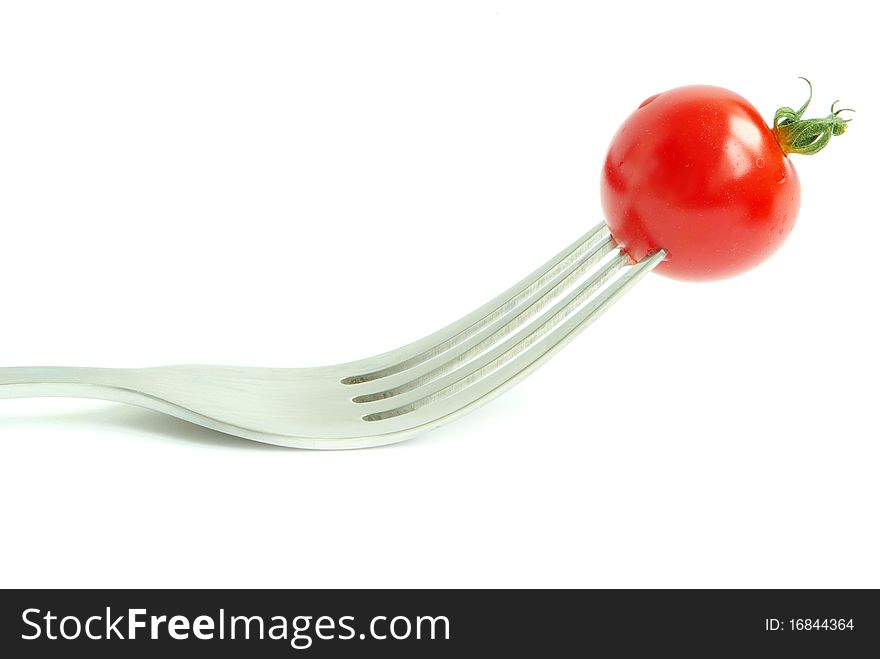 Fresh tomato on the fork on white