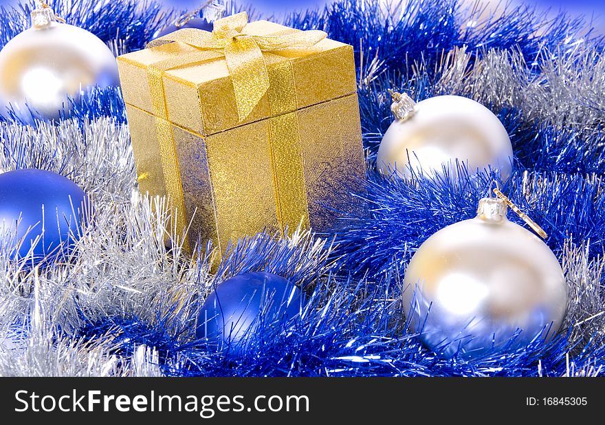 Christmas giftbox on background with crystal balls and Christmas ornaments