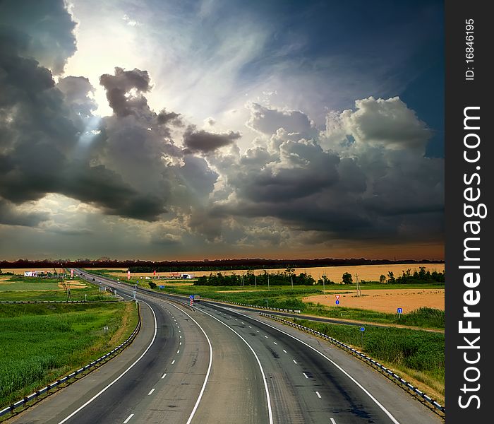 Asphalt road with a fence against the blue sky