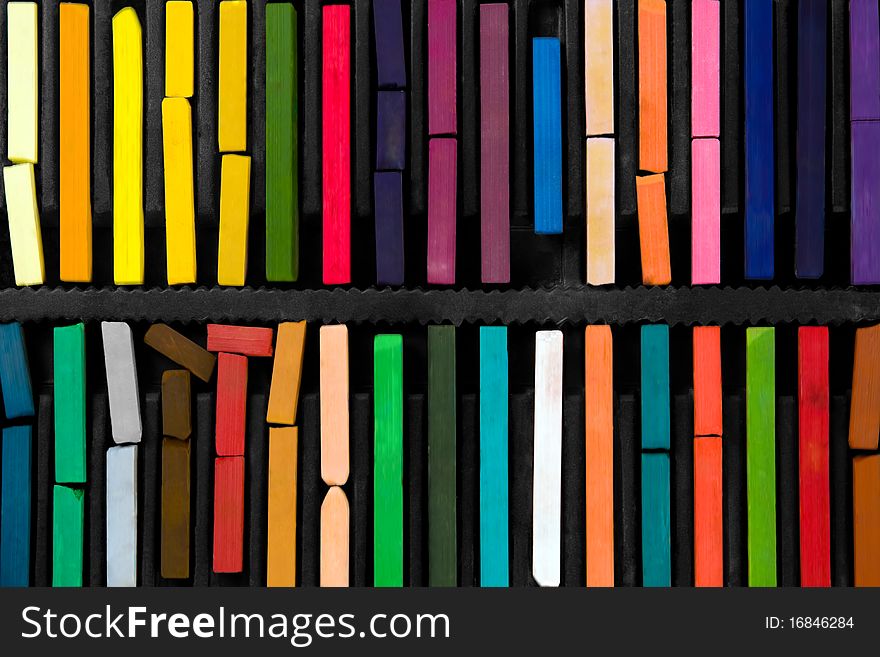 Bars of bright and colorful pastel on black background