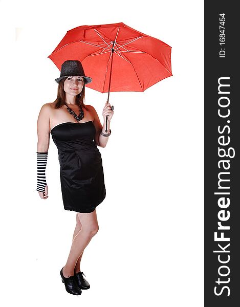 An middle aged woman in an short black dress and a gray hat standing in the studio with a red umbrella in her hand. An middle aged woman in an short black dress and a gray hat standing in the studio with a red umbrella in her hand.