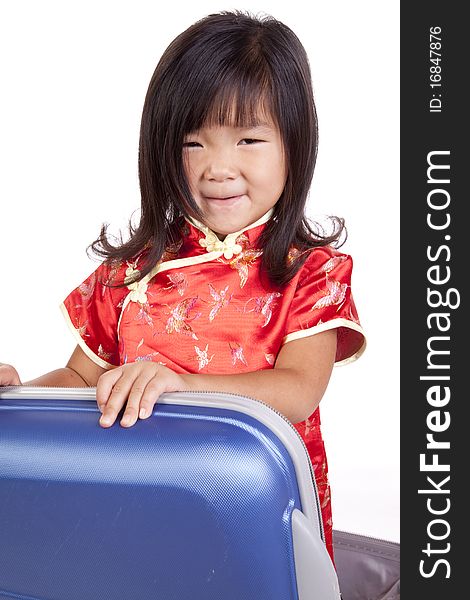 A young chinese girl is sitting in a suitcase. A young chinese girl is sitting in a suitcase.