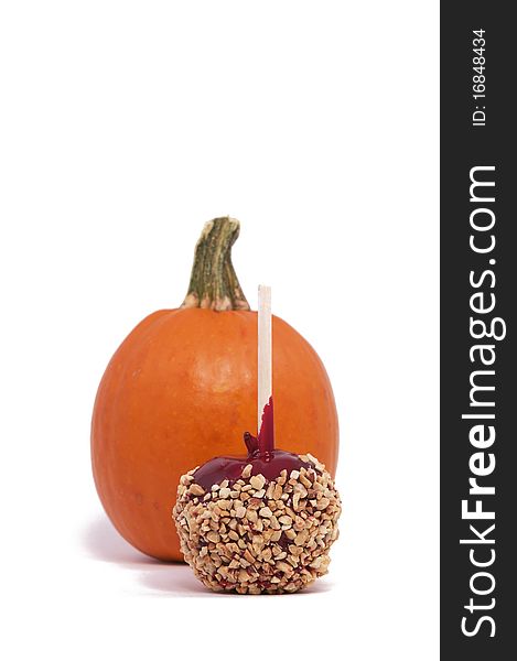 A Candy Apple and Small Pumpkin Isolated against a White Background. A Candy Apple and Small Pumpkin Isolated against a White Background