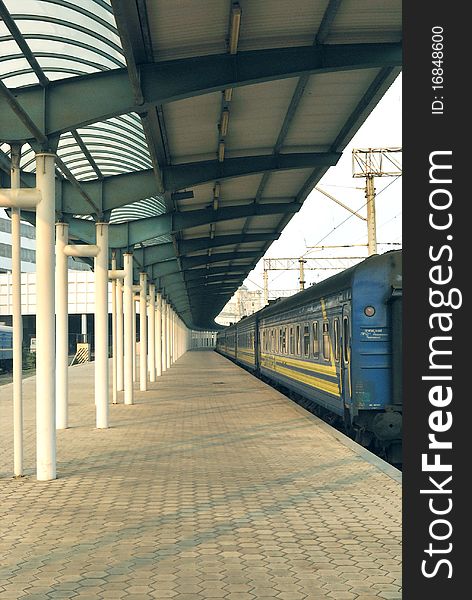 It is early morning at the railway station when there are no peoples at the platform. The passenger train waits the hour of departure. This shoot is made in one of the Ukrainian towns. It is early morning at the railway station when there are no peoples at the platform. The passenger train waits the hour of departure. This shoot is made in one of the Ukrainian towns.