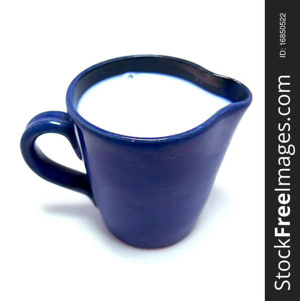 A blue ceramic jug with wilk on a white background. A blue ceramic jug with wilk on a white background.