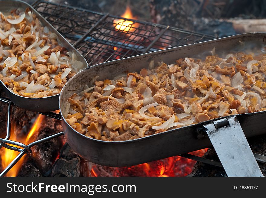 Mushrooms are fried with an onions on a fire. Mushrooms are fried with an onions on a fire
