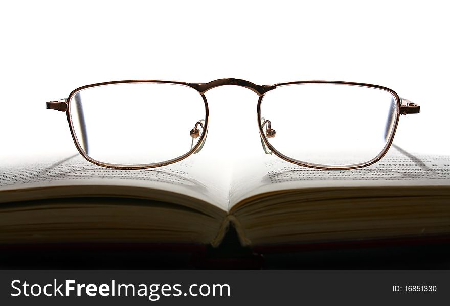 Book and glasses isolated on white background