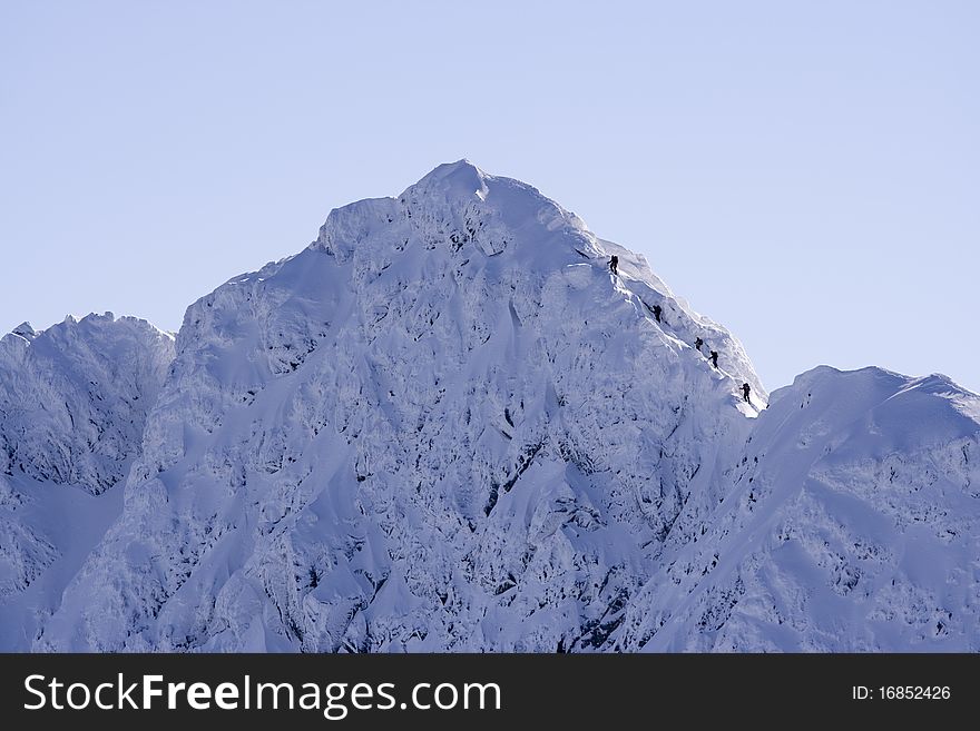 Group of climbers approaching a snowy peak