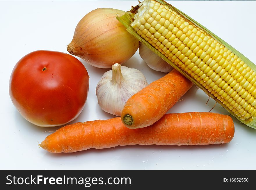 Fresh vegetables on a cut table. Tomato, onion, corn, garlic