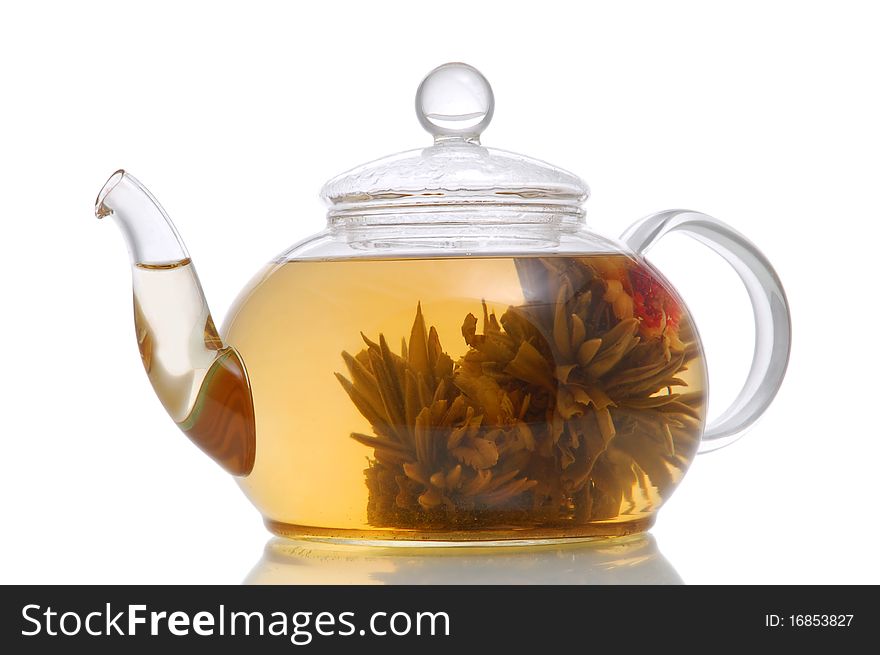 Glass teapot with blooming flower green tea on white background
