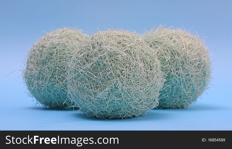 Three fluffy yarns against blue background