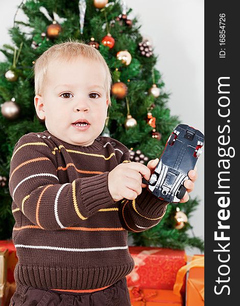 Baby boy playing with a toy car at christmas