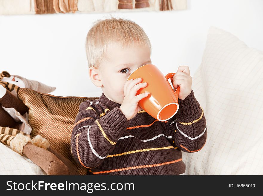 Sweet baby boy drinking from a big jar