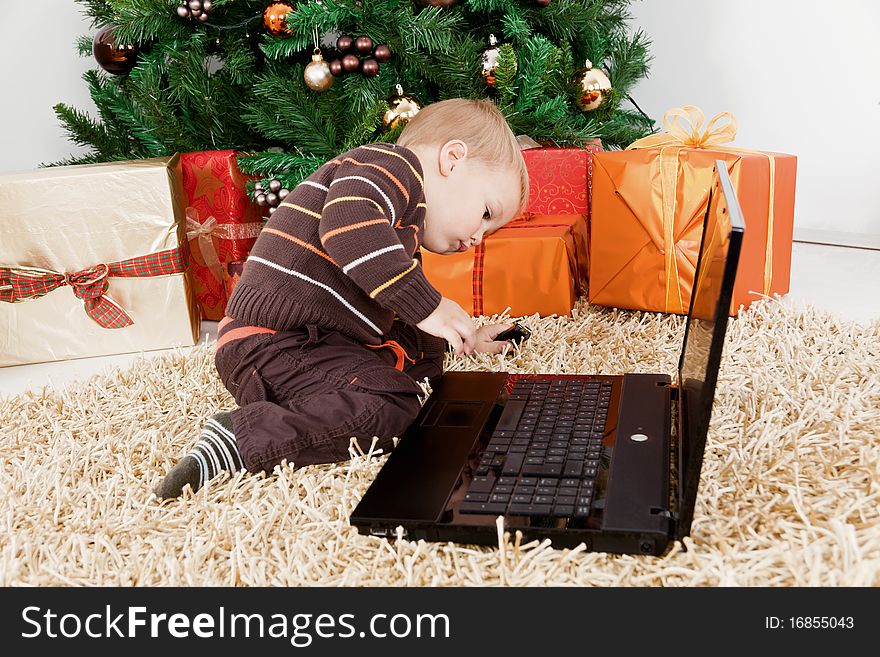 Baby boy playing with a laptop at christmas