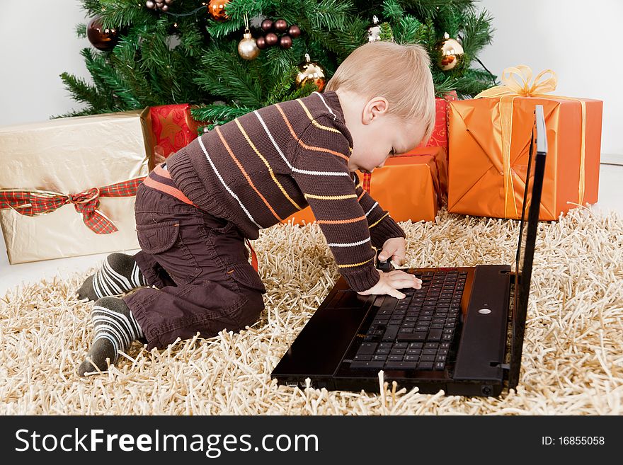 Baby boy playing with a laptop at christmas