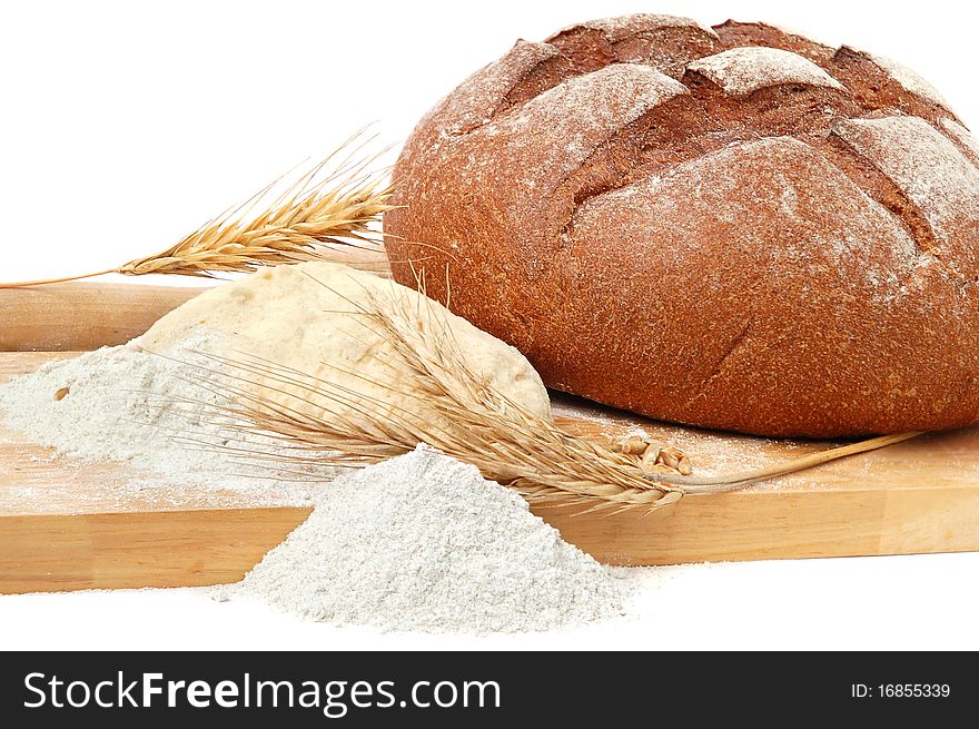 Still life with bread, dough, flour and rolling-pin on a wooden board. Still life with bread, dough, flour and rolling-pin on a wooden board